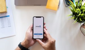 Person holding phone with LinkedIn open on it